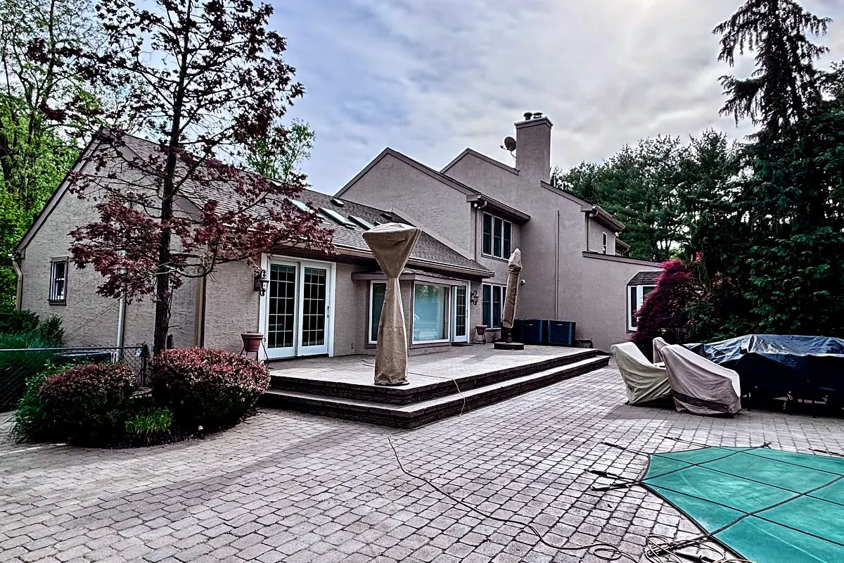 Restored stucco exterior of a Moorestown, NJ home — side and front view after repair and finishing work