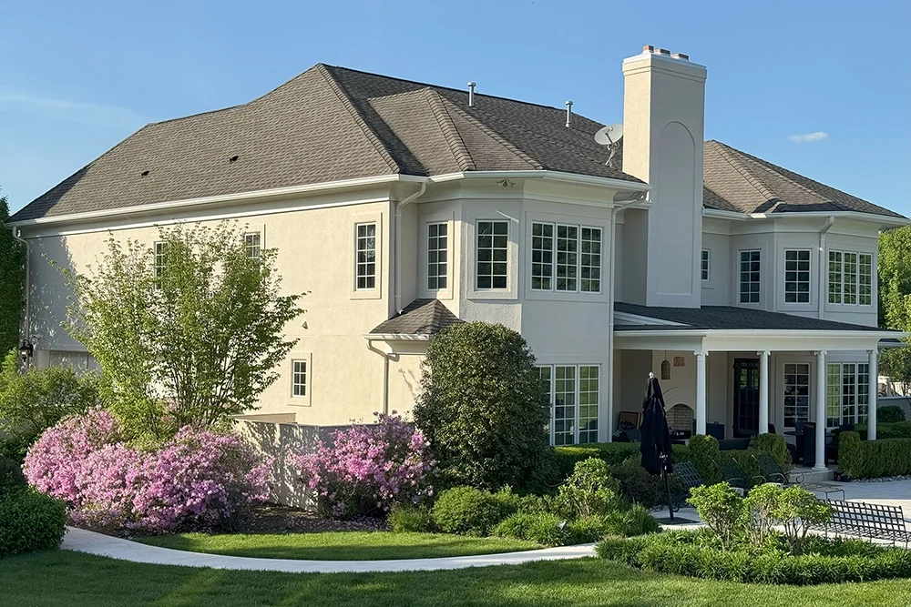 Two-story home with light stucco exterior and chimney, refreshed by ZD Stucco Repair in Mendham, NJ