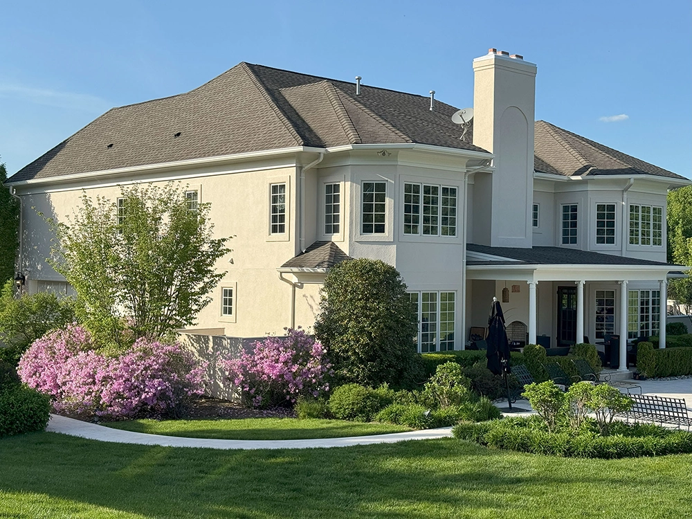 Home 11 Two-story home with light stucco exterior and chimney, refreshed by ZD Stucco Repair in Mendham, NJ