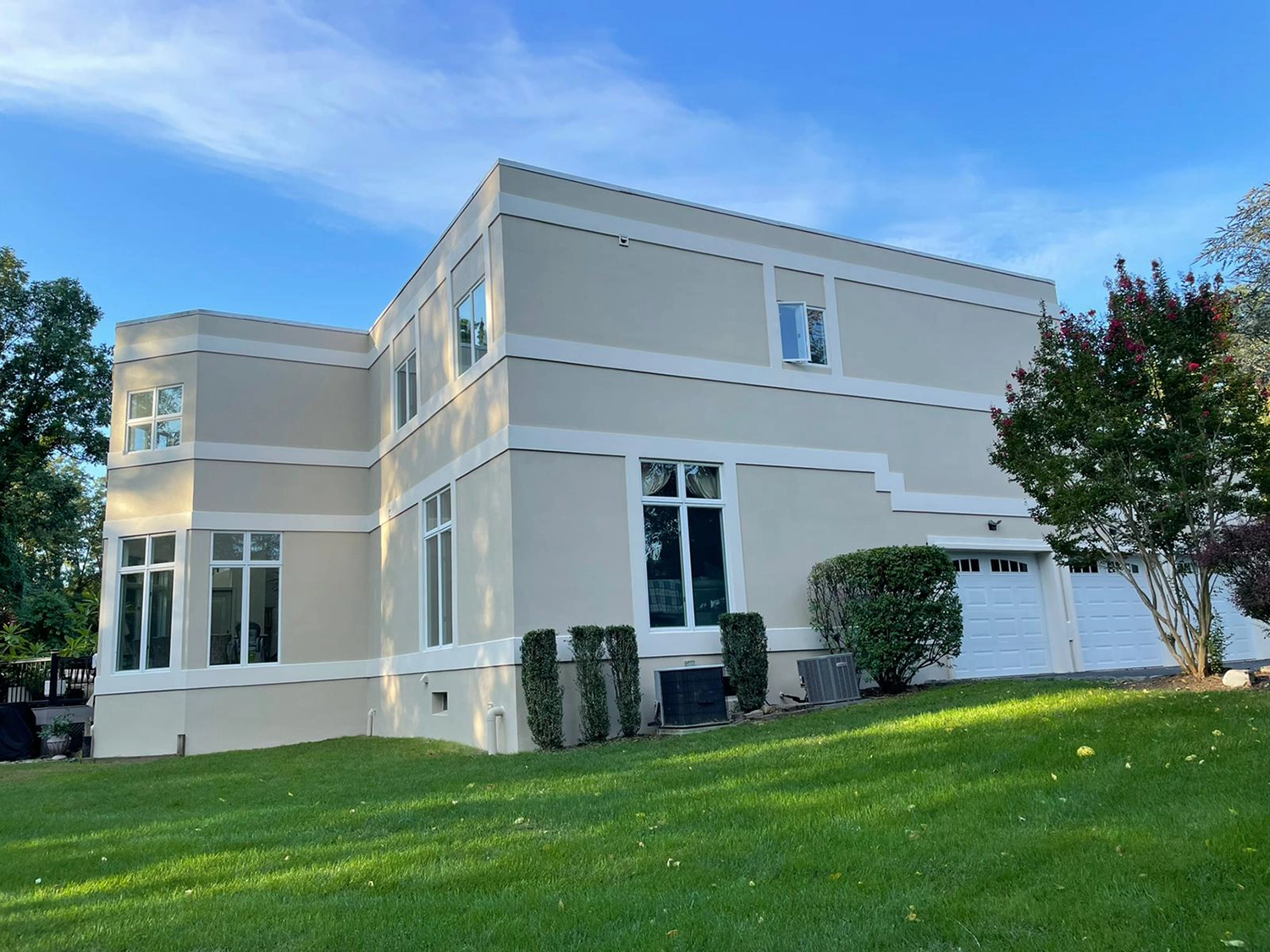Does Stucco Add Value to Your Home? 4 Modern two-story stucco home with smooth finish and contrasting bands following repair and repaint.