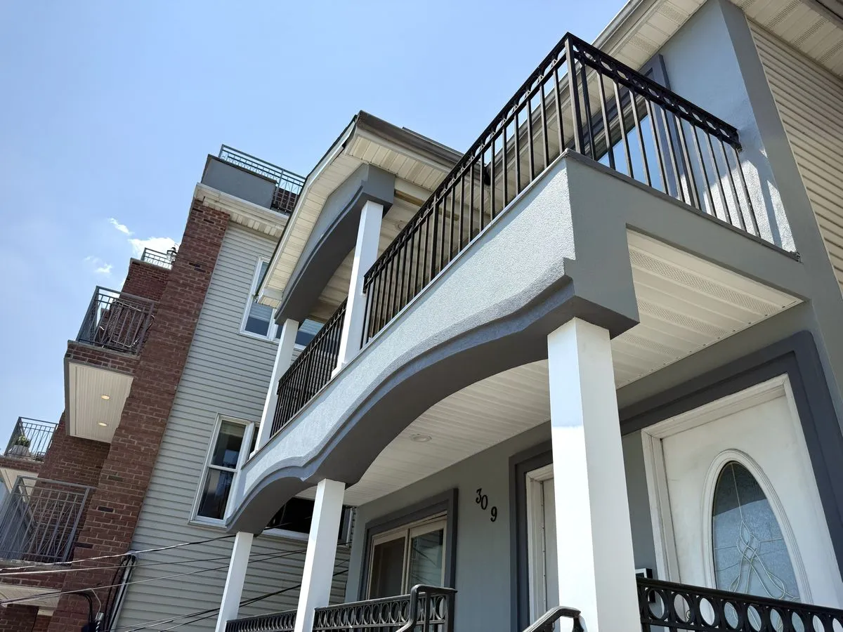 Original balcony with failing stucco and structural rot