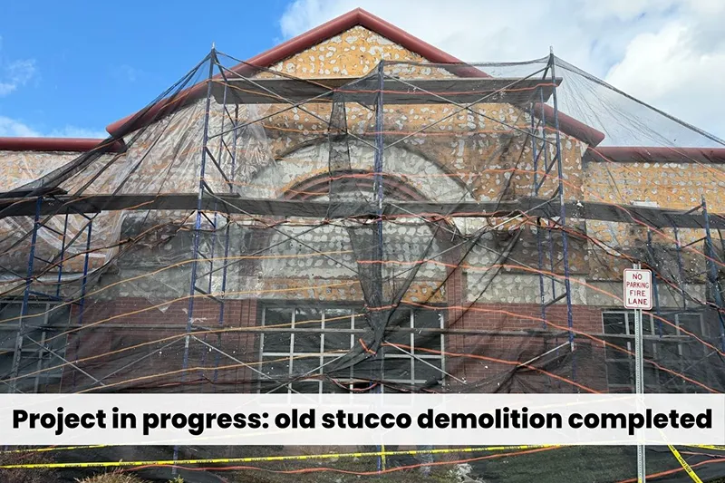 Scaffolded Wells Fargo branch in Clifton NJ after old stucco demolition, exposing wall substrate and detailing before EIFS reconstruction by ZD Stucco Repair.