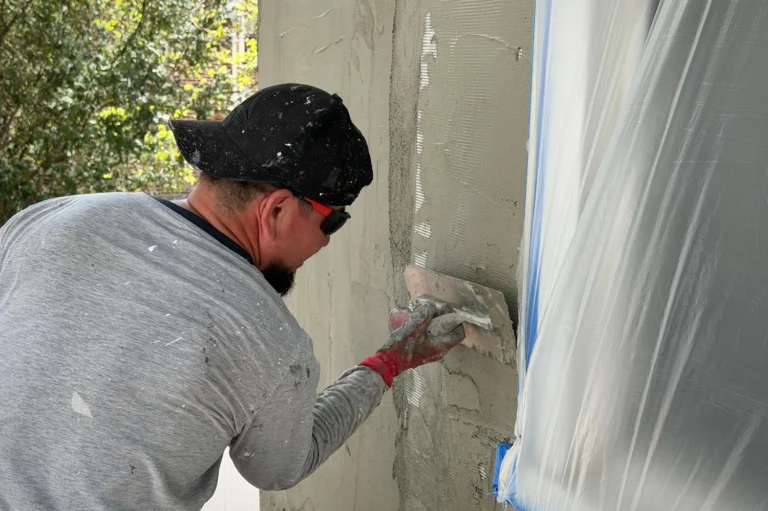Stucco contractor applying new stucco over mesh during exterior wall repair on a New Jersey home