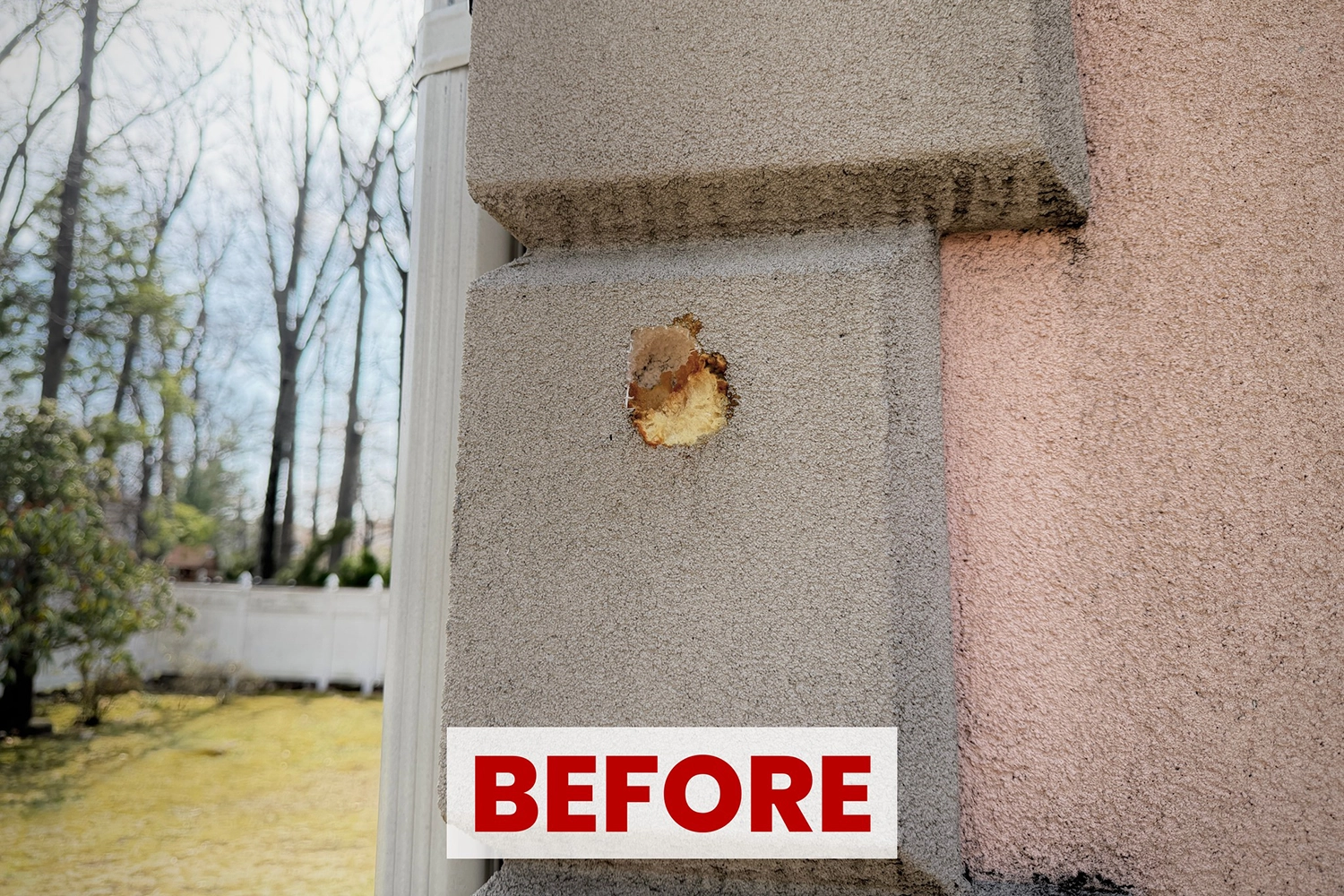 Close-up of bird hole damage and staining in stucco trim before repair