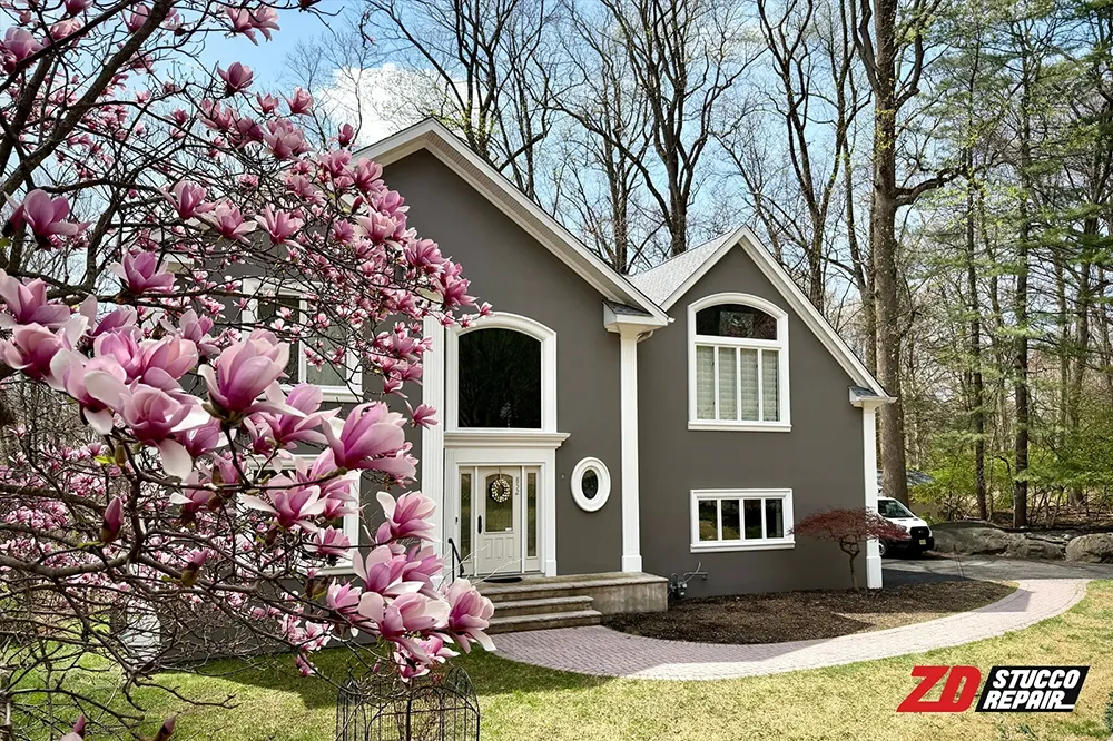 Finished Franklin Lakes stucco restoration with gray exterior coating and white trim by ZD Stucco Repair