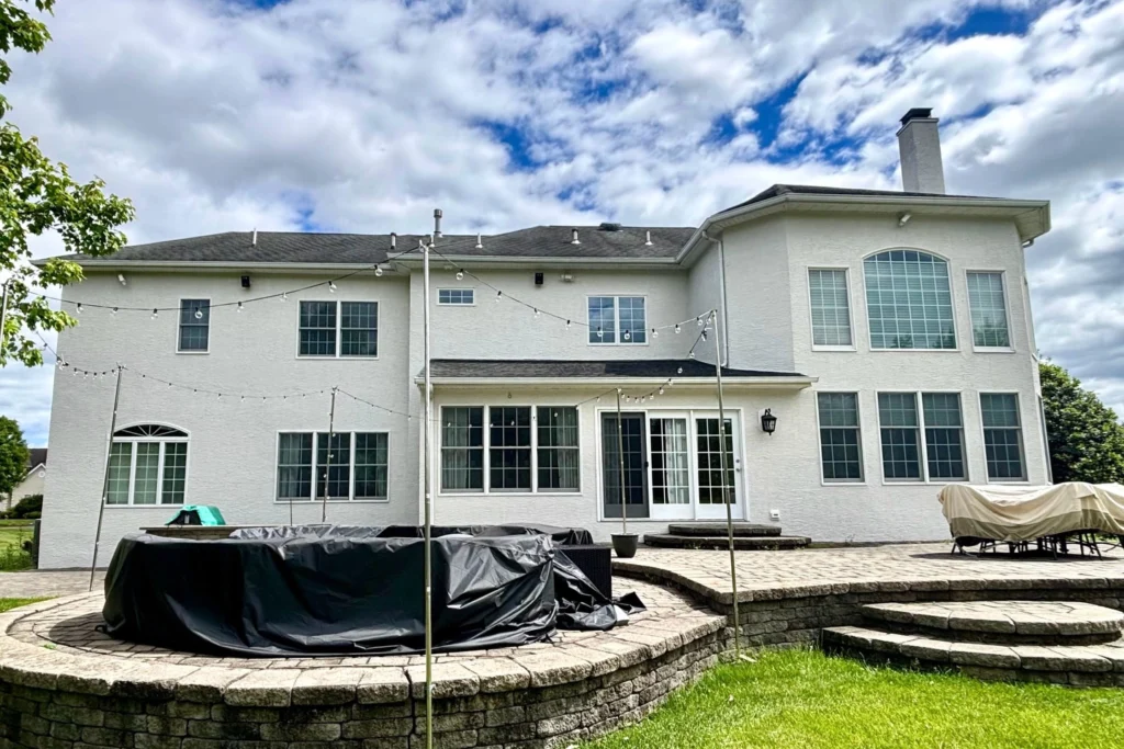 Complete House Stucco Restoration in Flemington, NJ: A Case Study 5 Stucco restoration work in progress on Flemington home backyard, showing protective coverings, equipment setup, and professional restoration process for entire house exterior