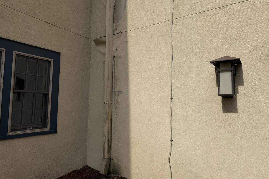 How We Restored a Historic 1930 Castle to Its Original Glory: Lake Mohawk Country Club Stucco Restoration 4 Close-up of damaged historic stucco wall showing moisture issues before restoration work at Lake Mohawk Country Club