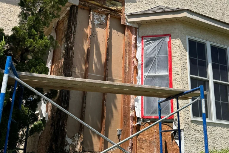 Rotted OSB sheathing exposed after damaged exterior material was removed