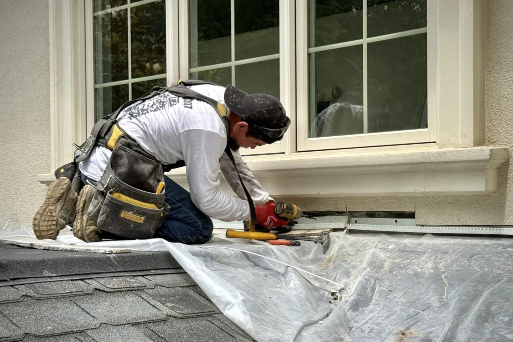 ZD Stucco Repair contractor installing kickout flashing at roof-wall transition on a New Jersey home during stucco remediation