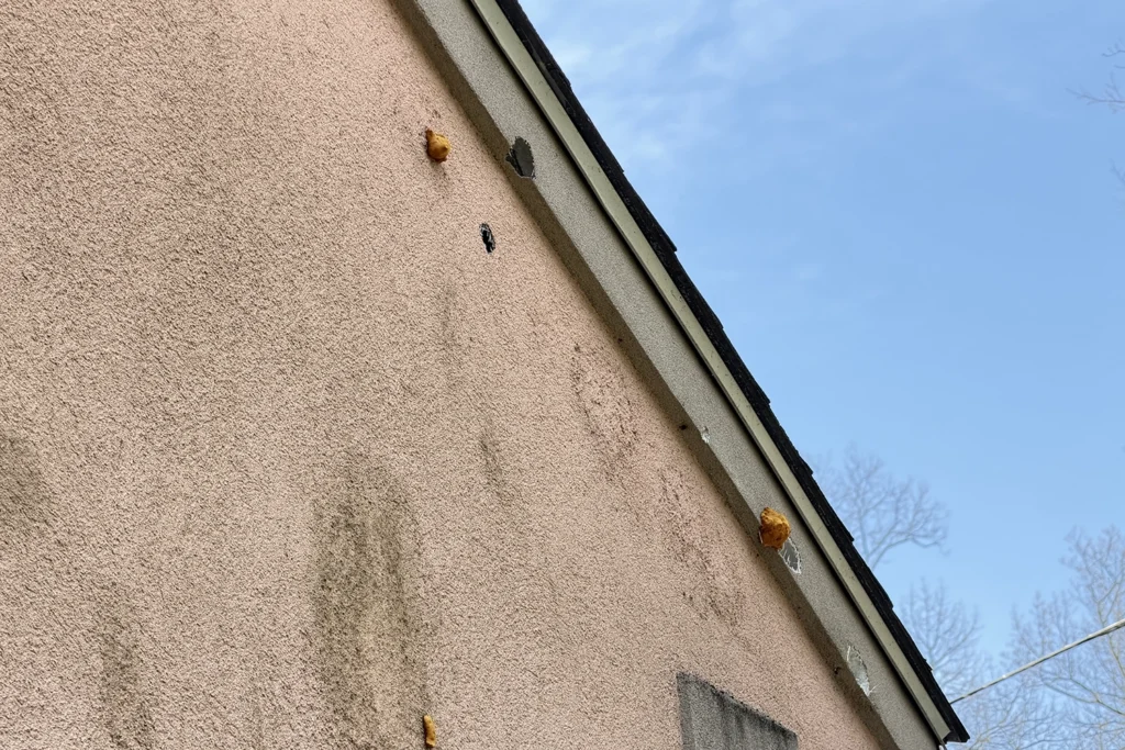 EIFS Synthetic Stucco Problems & Solutions in New Jersey 5 Rust bleed spots and water staining on a stucco wall near the roofline of a New Jersey home, indicating failed flashing and moisture penetration that can lead to wood rot behind stucco