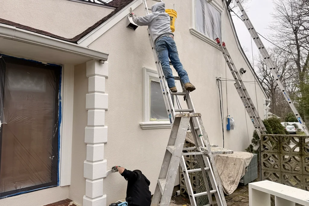 Stucco Repair vs Repainting: What Does Your New Jersey Home Need? 6 Contractors preparing and protecting a stucco home before exterior repainting