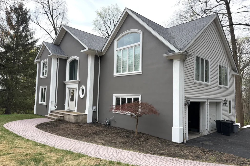 Smooth Stucco Finish: Pros, Cons, Cost & Common Problems 8 Restored stucco exterior showing the front and right side of a Franklin Lakes home