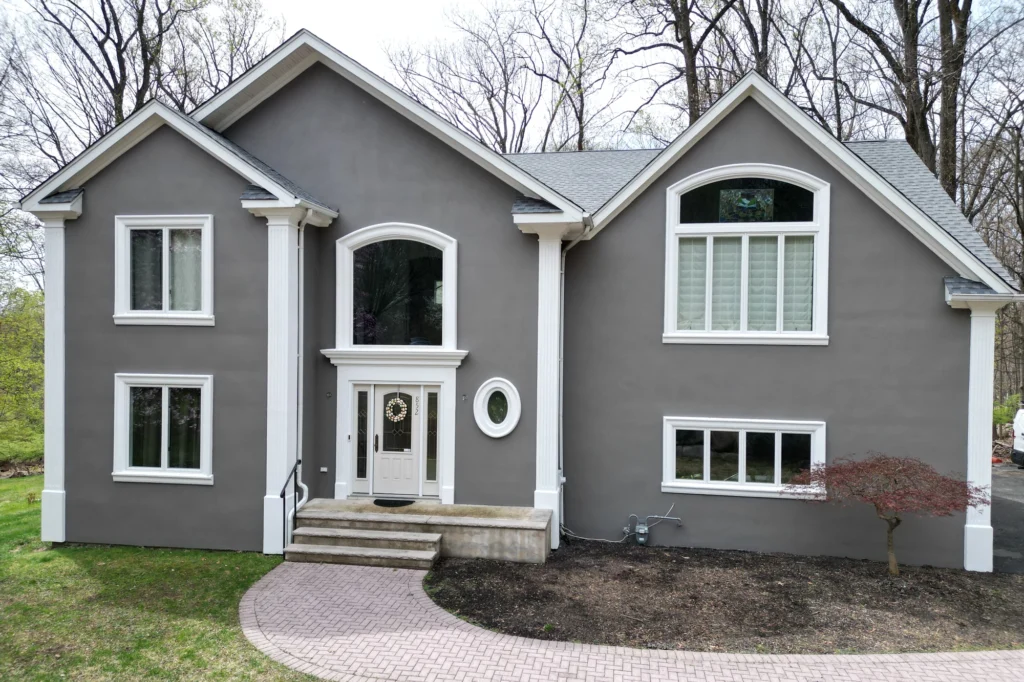 15 Gray Stucco House Ideas: Light, Dark, White Trim & Black Accents 13 Restored front stucco facade of a Franklin Lakes home viewed straight on