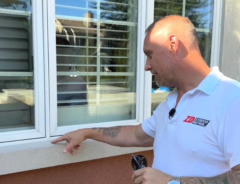 ZD Stucco Repair owner Zoltan Dicso inspecting stucco beneath an exterior window