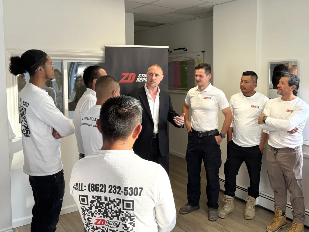 Zoltan Dicso, founder of ZD Stucco Repair, speaking with the company team during a staff meeting