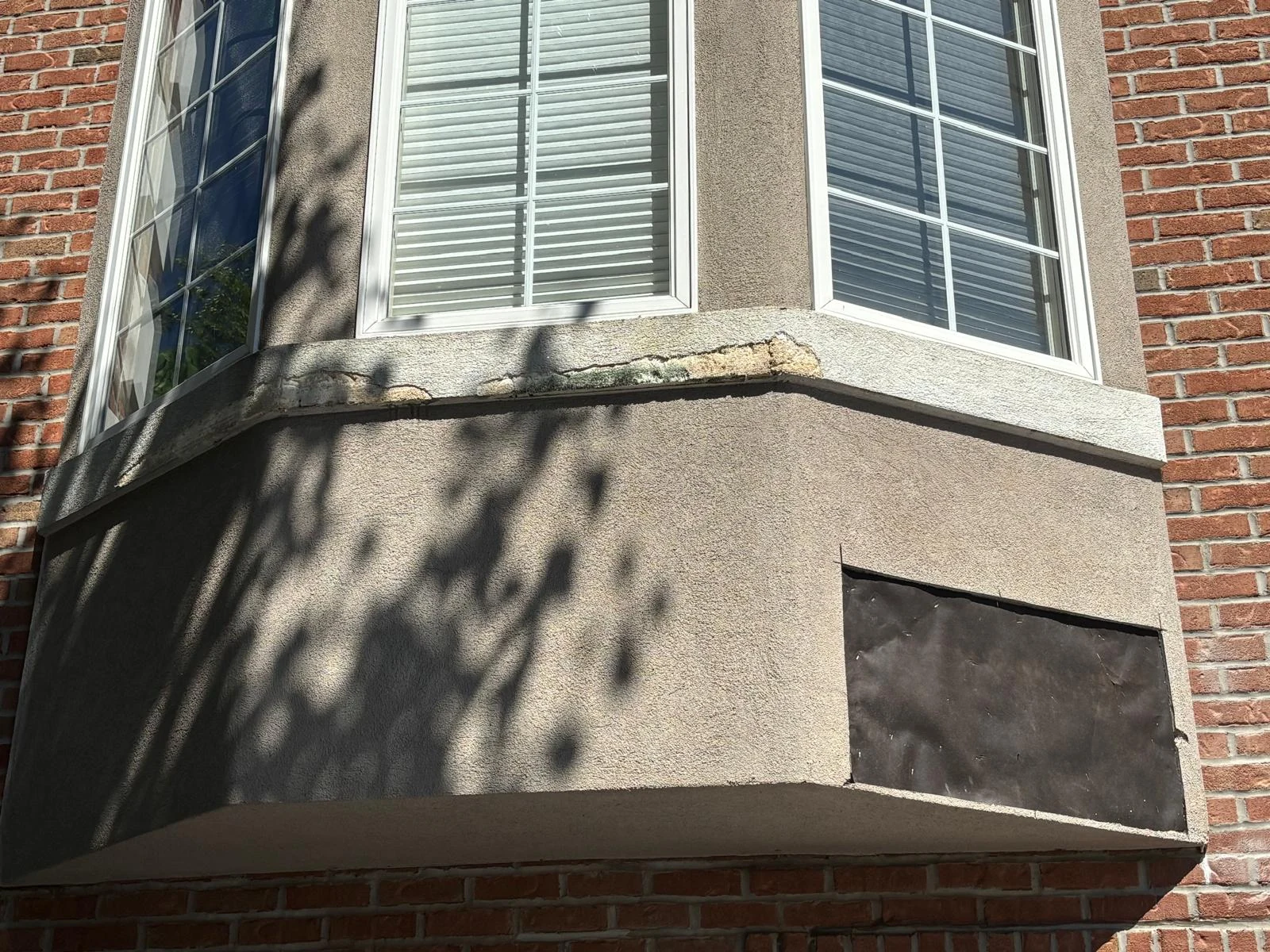 Cracked and peeling exterior trim below a bay window at the Cresskill project.