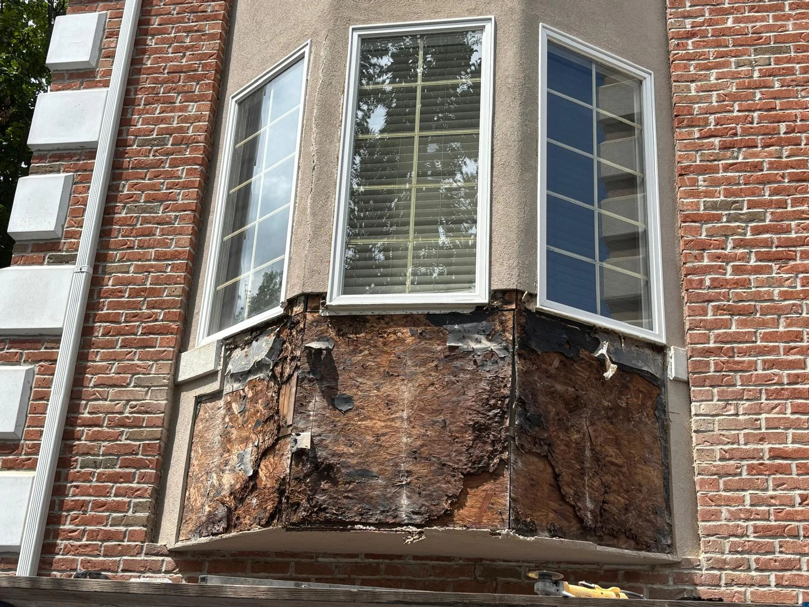 Exposed, deteriorated wood sheathing below a bay window at the Cresskill project.